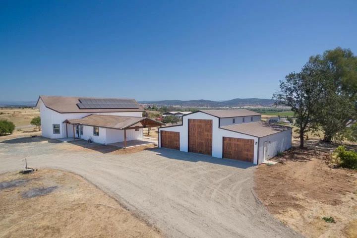 An aerial view of a large white house with three garages.