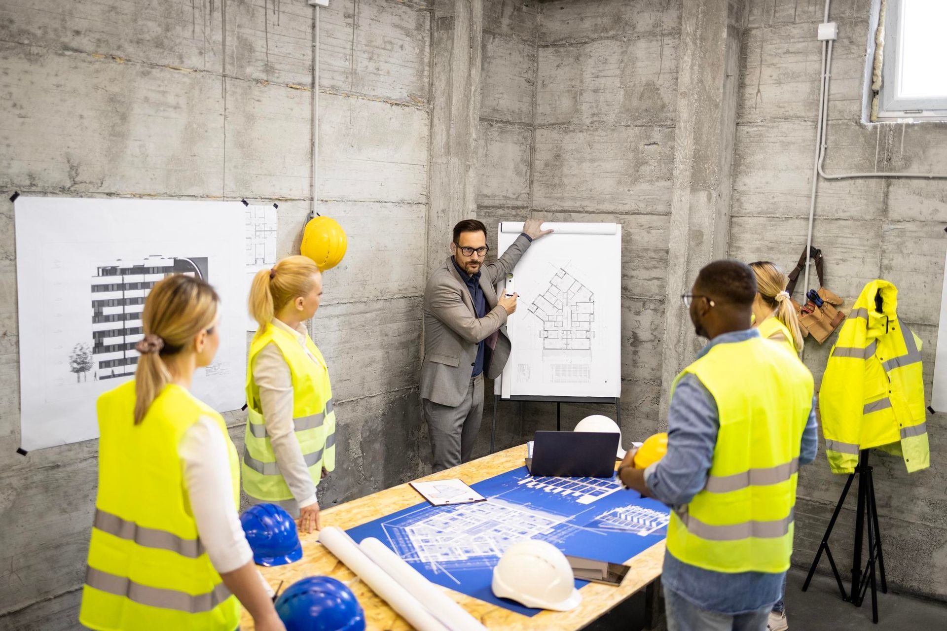 a group of construction workers are having a meeting in a room .