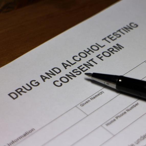 A pen rests on a drug and alcohol testing consent form