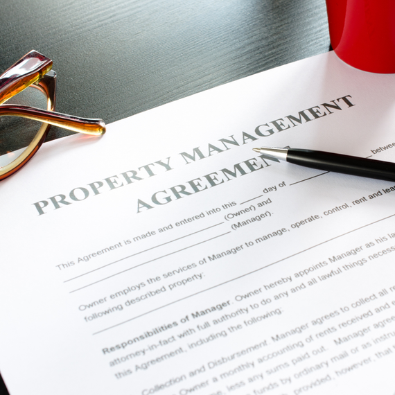 A property management agreement with glasses and a pen on it