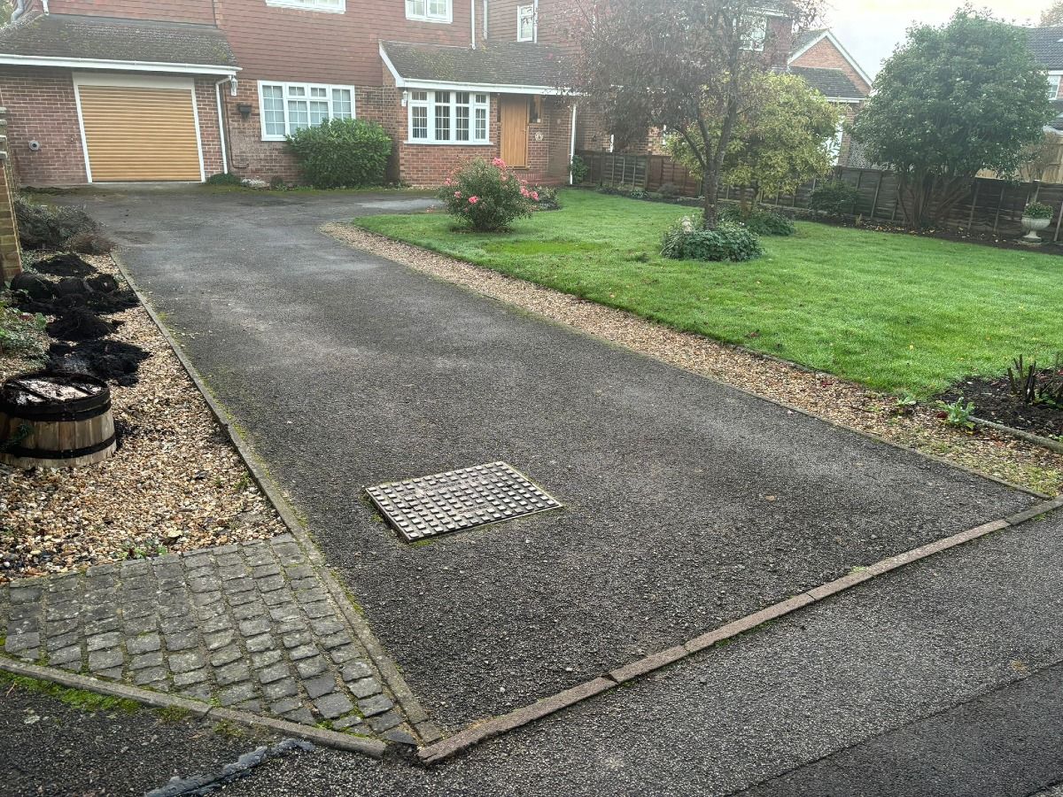 Brick house with driveway and front lawn on a wet day