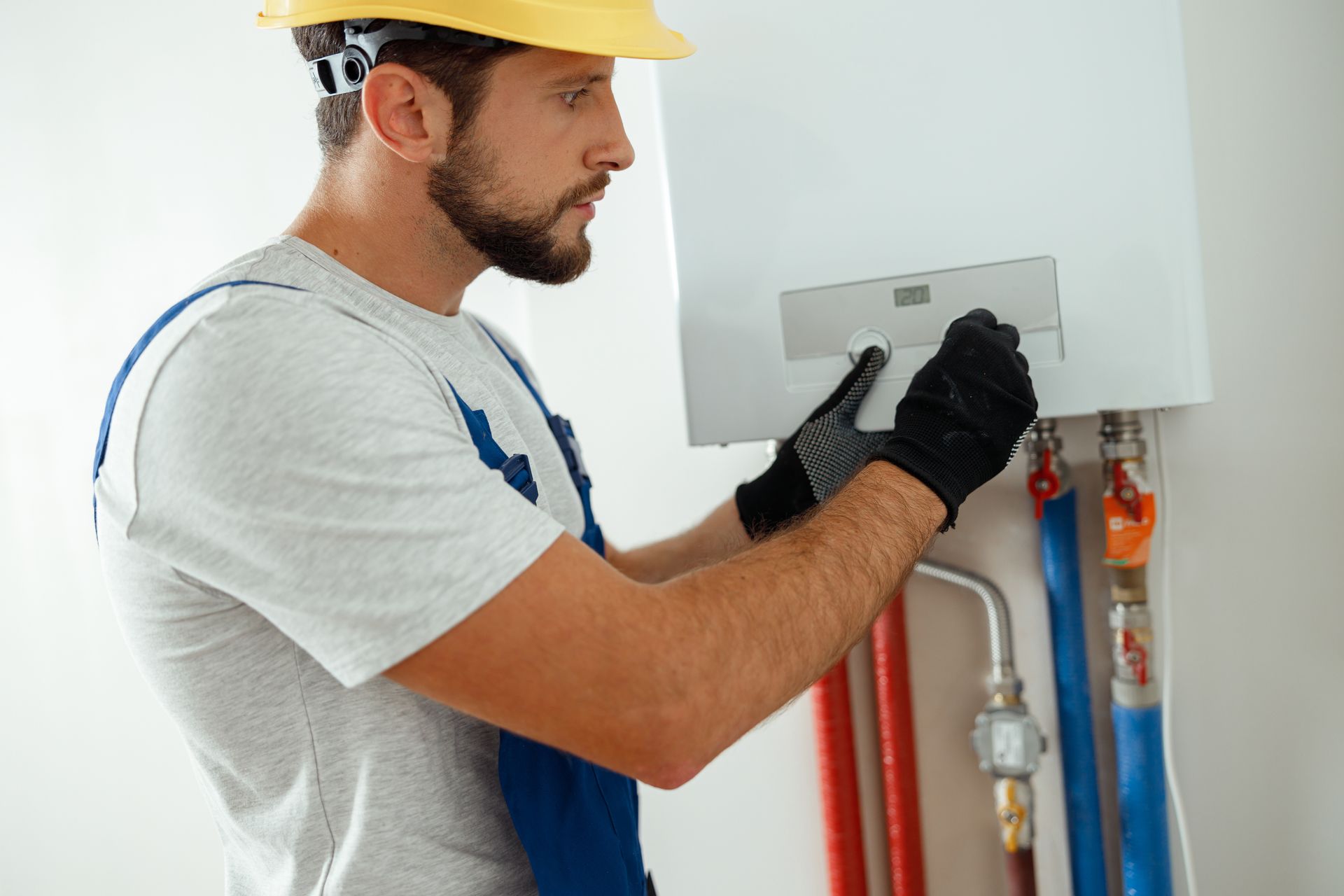Heating services technician adjusting indoor water heater system.