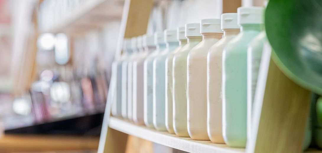 A Row of Bottles Sitting on Top of a Wooden Shelf - Niddrie, VIC  - Koukla Hair Studio