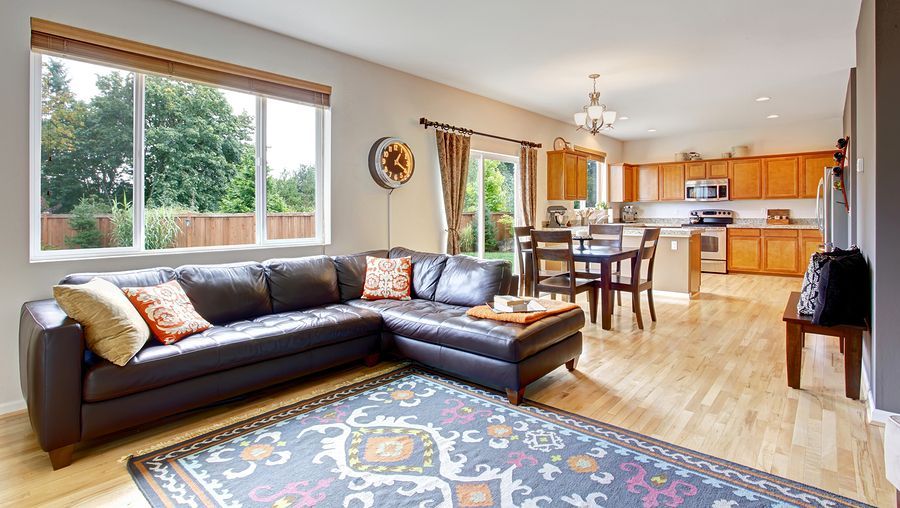 A living room with a large sectional couch and a rug