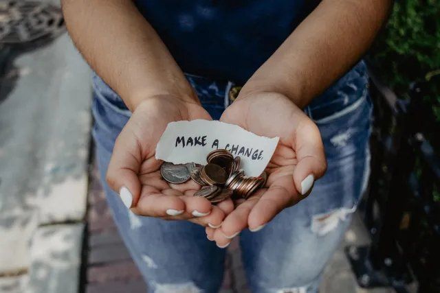 Hands holding change and a note that says make a change.