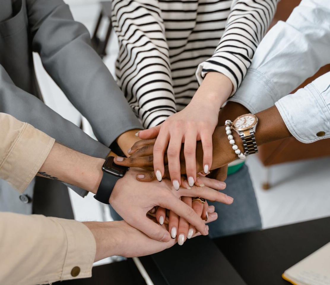 4 peoples hands on top of each other