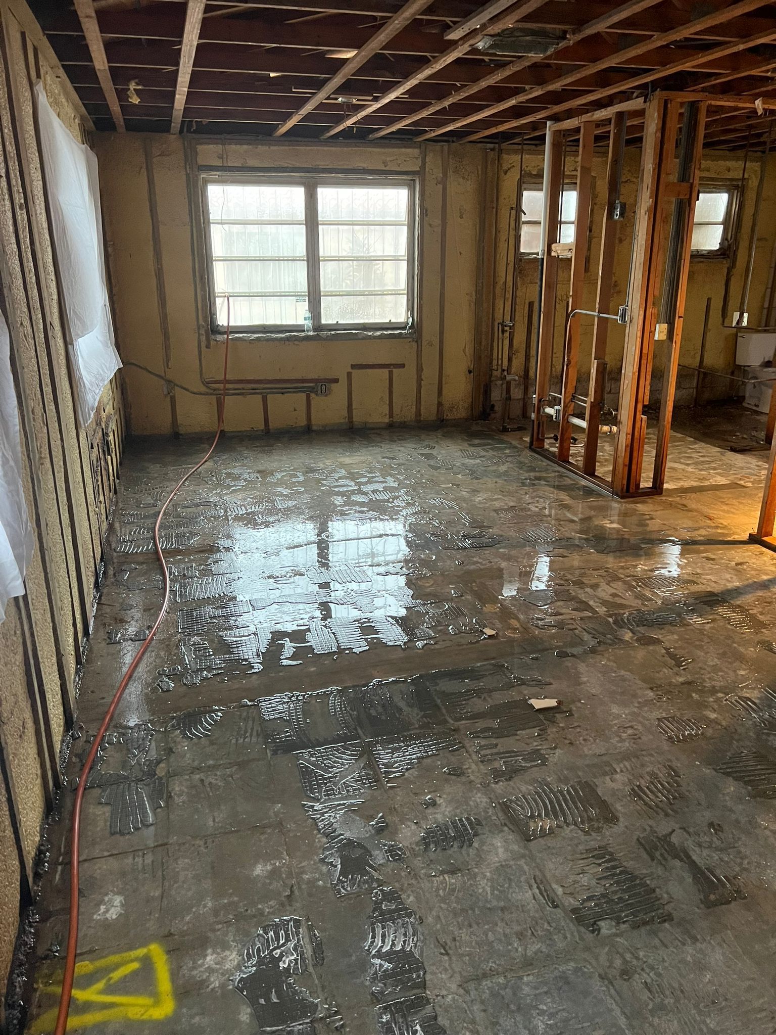 A room with a lot of water on the floor and a lot of windows.