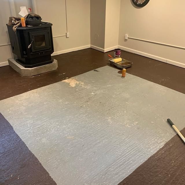 A room with a fireplace and a rug on the floor.