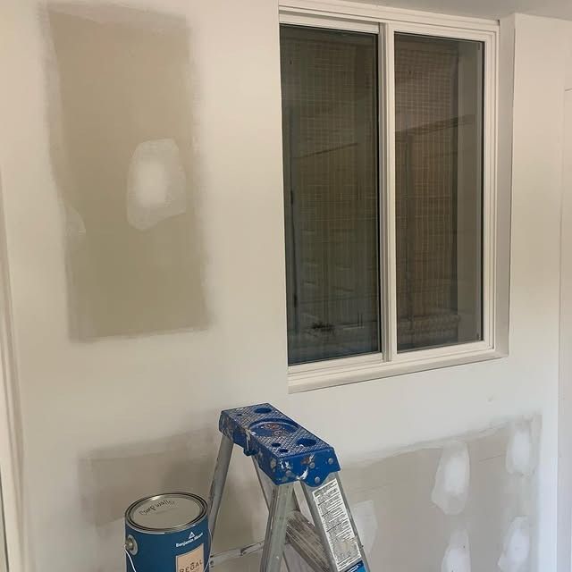 A ladder is sitting in front of a window in a room.