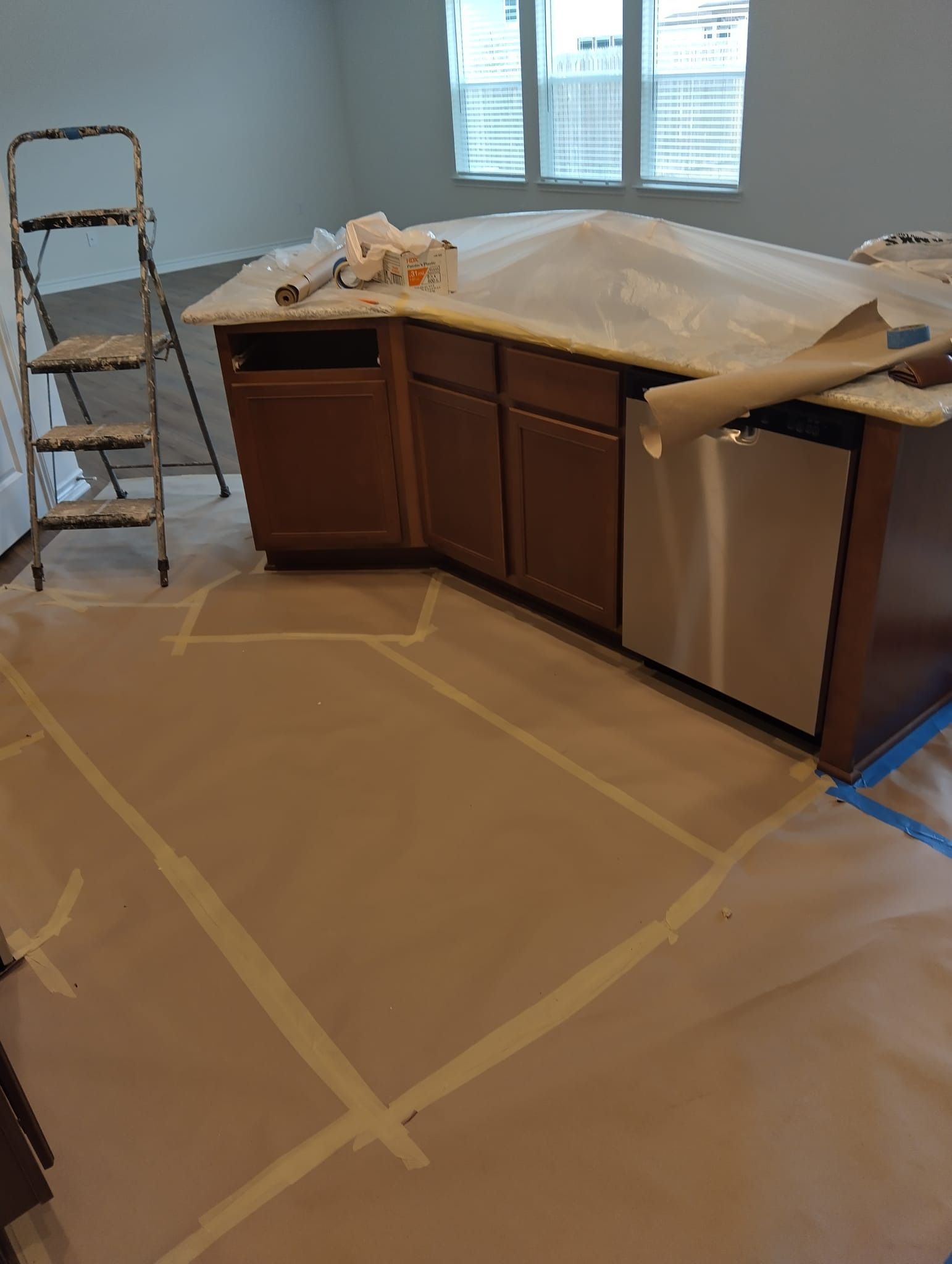 A kitchen is being painted with a ladder in the background.