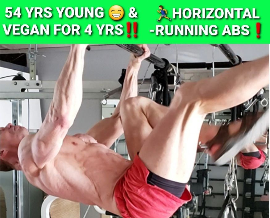 A man is hanging upside down in a gym with the words 54 yrs young and horizontal running abs