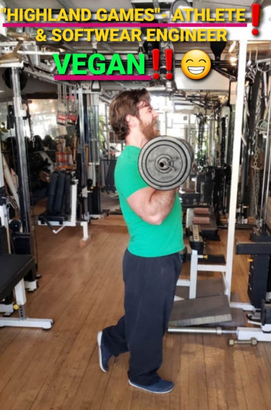 A man in a green shirt is lifting a barbell in a gym