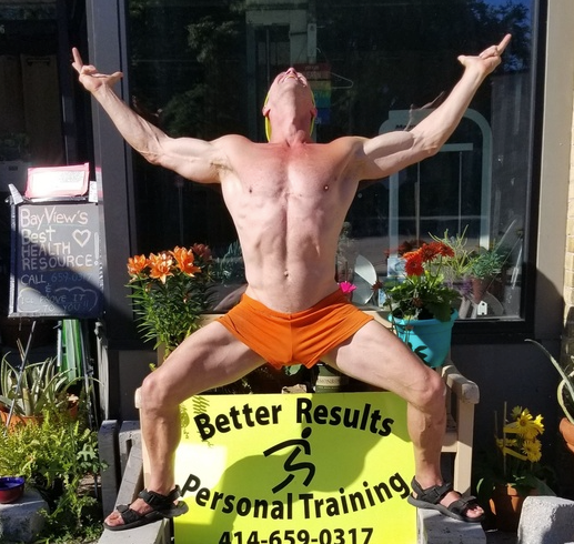 A shirtless man stands in front of a sign for better results personal training