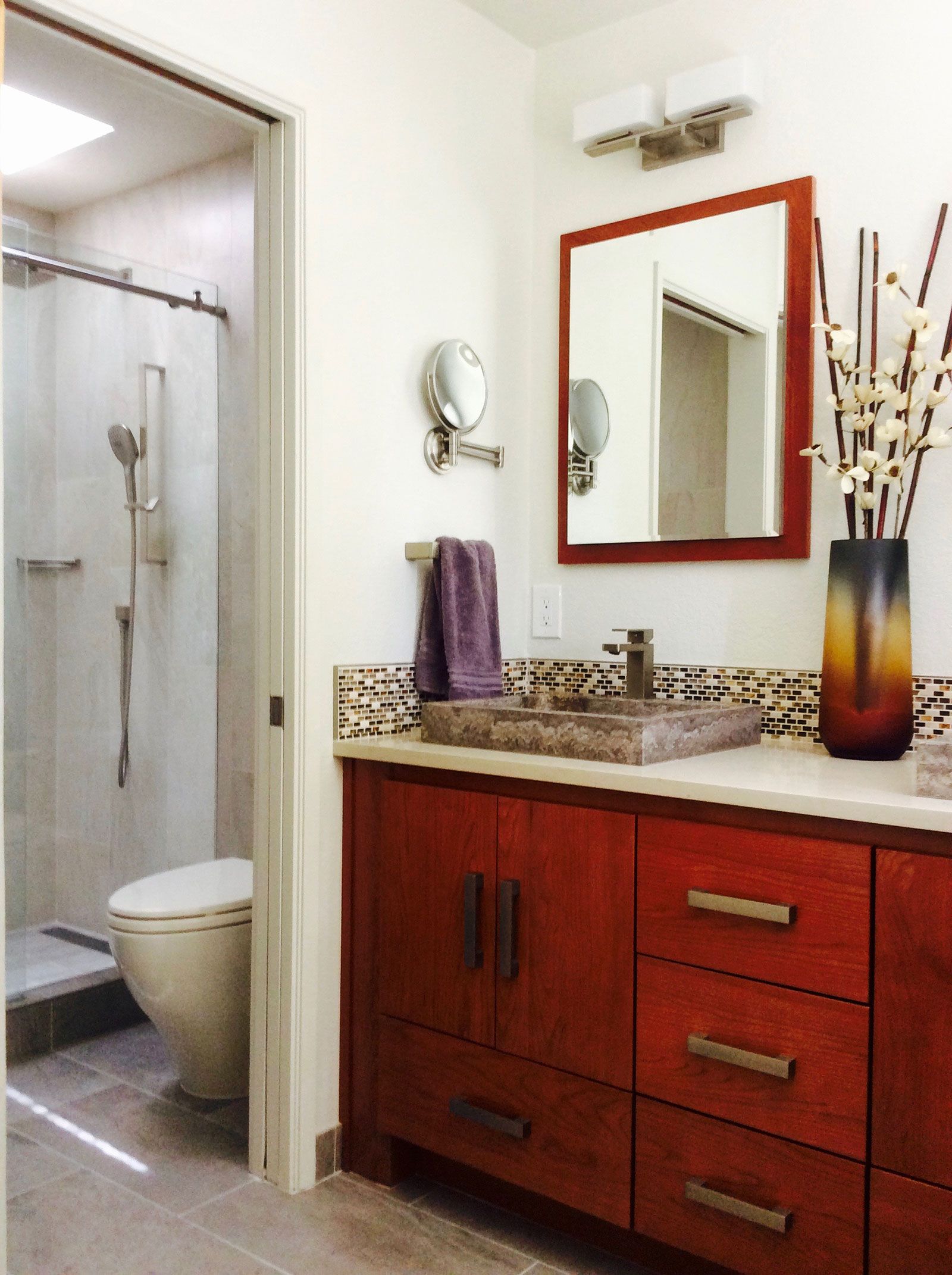 A bathroom with a toilet a sink and a mirror