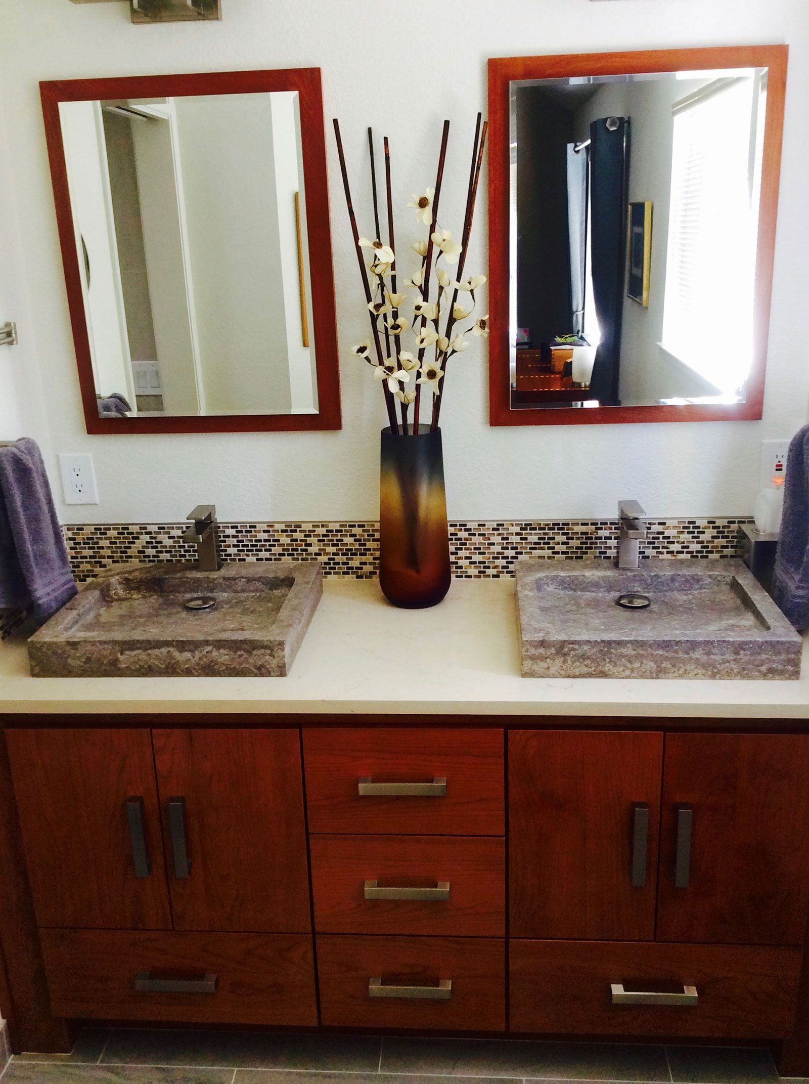 A bathroom with two sinks and two mirrors