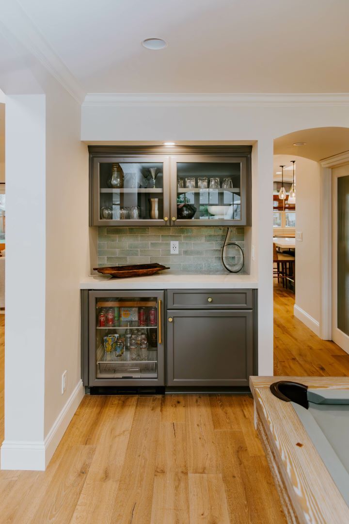 A kitchen with a bar and a refrigerator in it.
