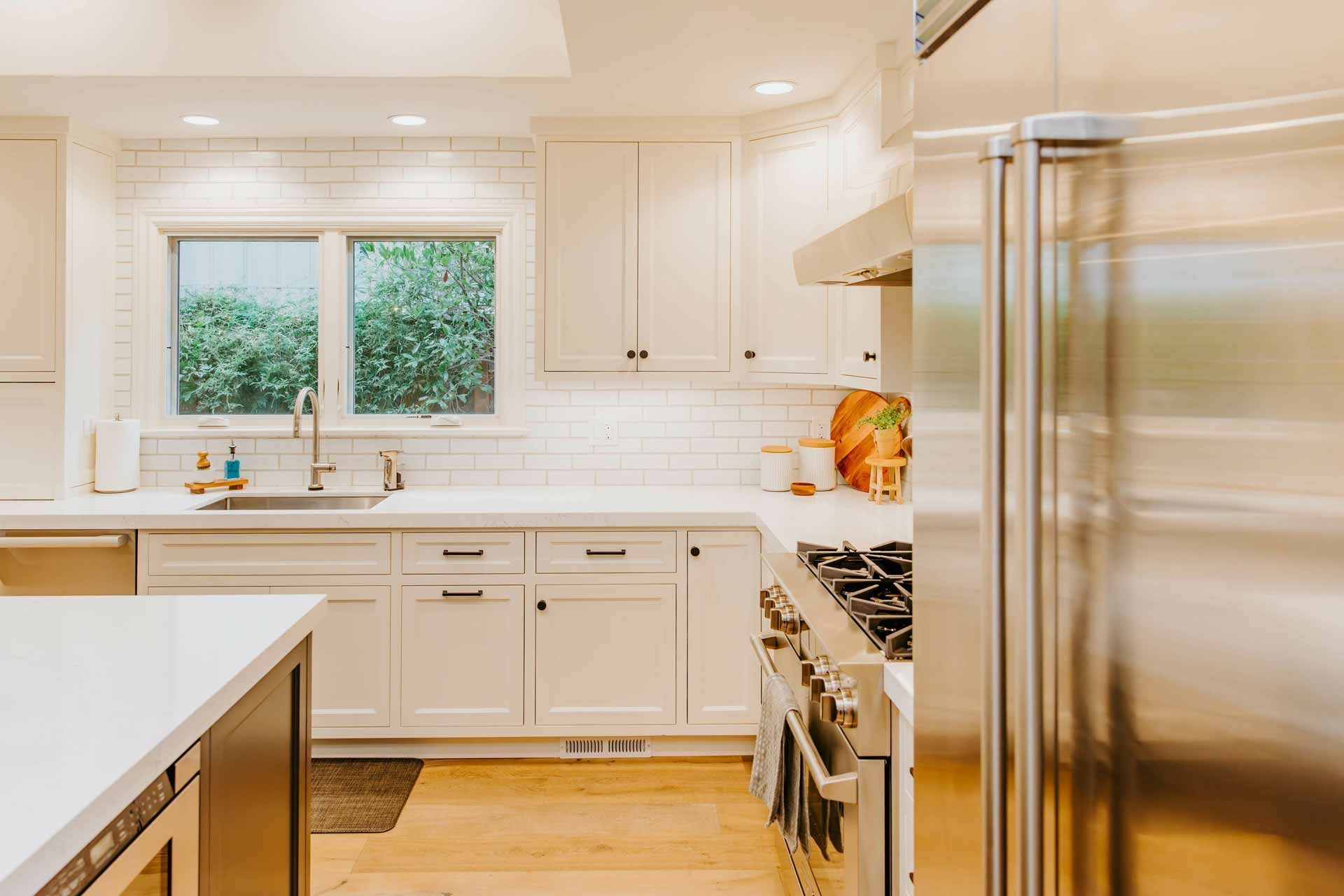 A kitchen with white cabinets and stainless steel appliances.