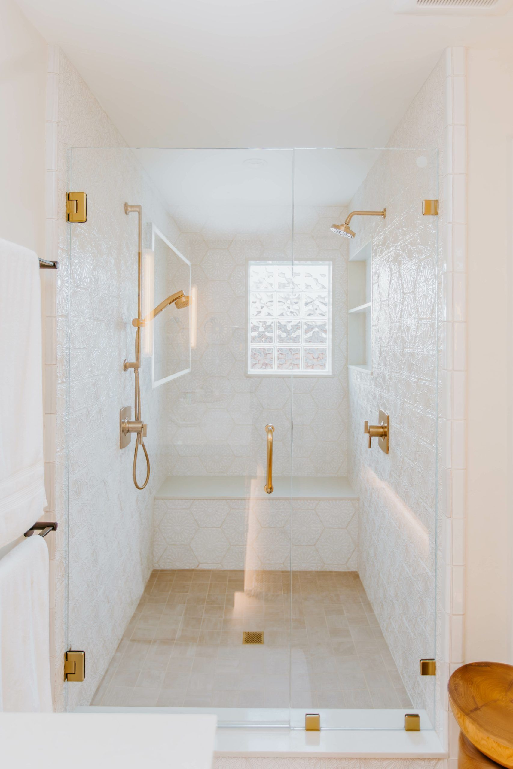 A bathroom with a walk in shower and a window.