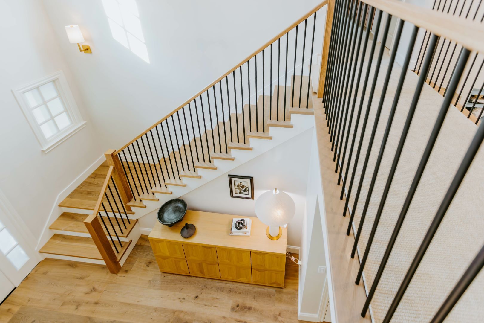 An aerial view of a staircase in a house with a wooden railing.