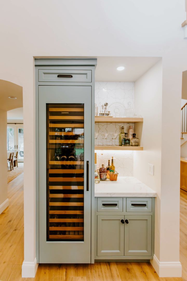 A kitchen with a wine cooler built into the wall.