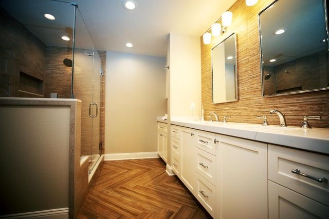 A bathroom with two sinks and a walk in shower.