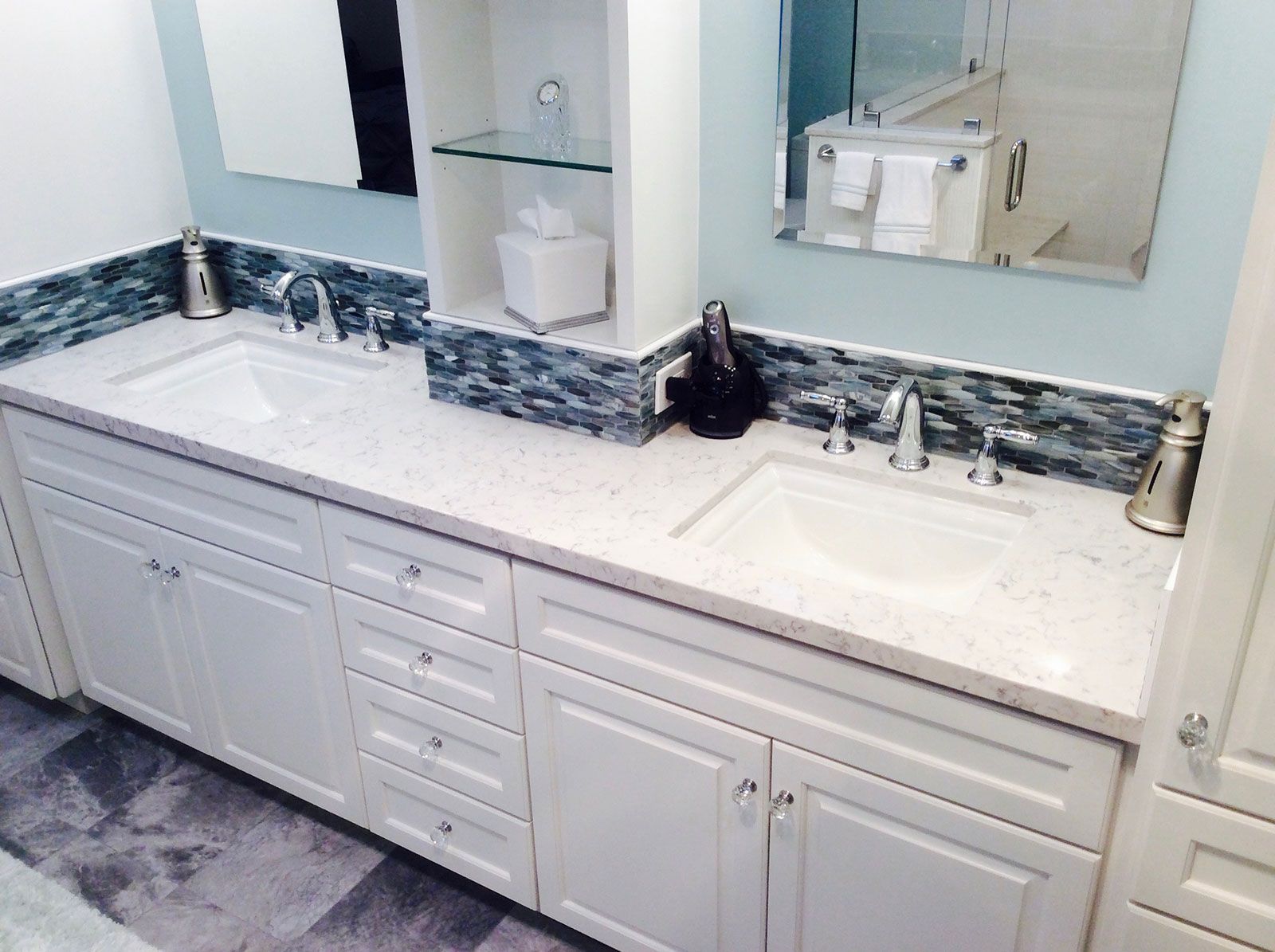 A bathroom with two sinks and a mirror