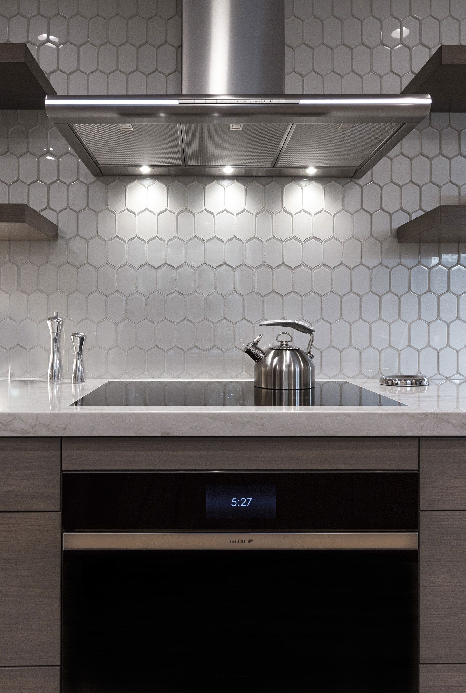 A kitchen with a stove top oven and a hood above it.