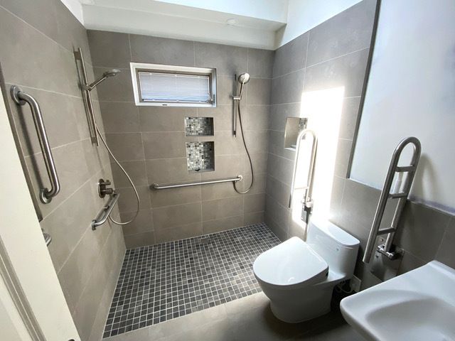 A bathroom with a walk in shower , toilet and sink.