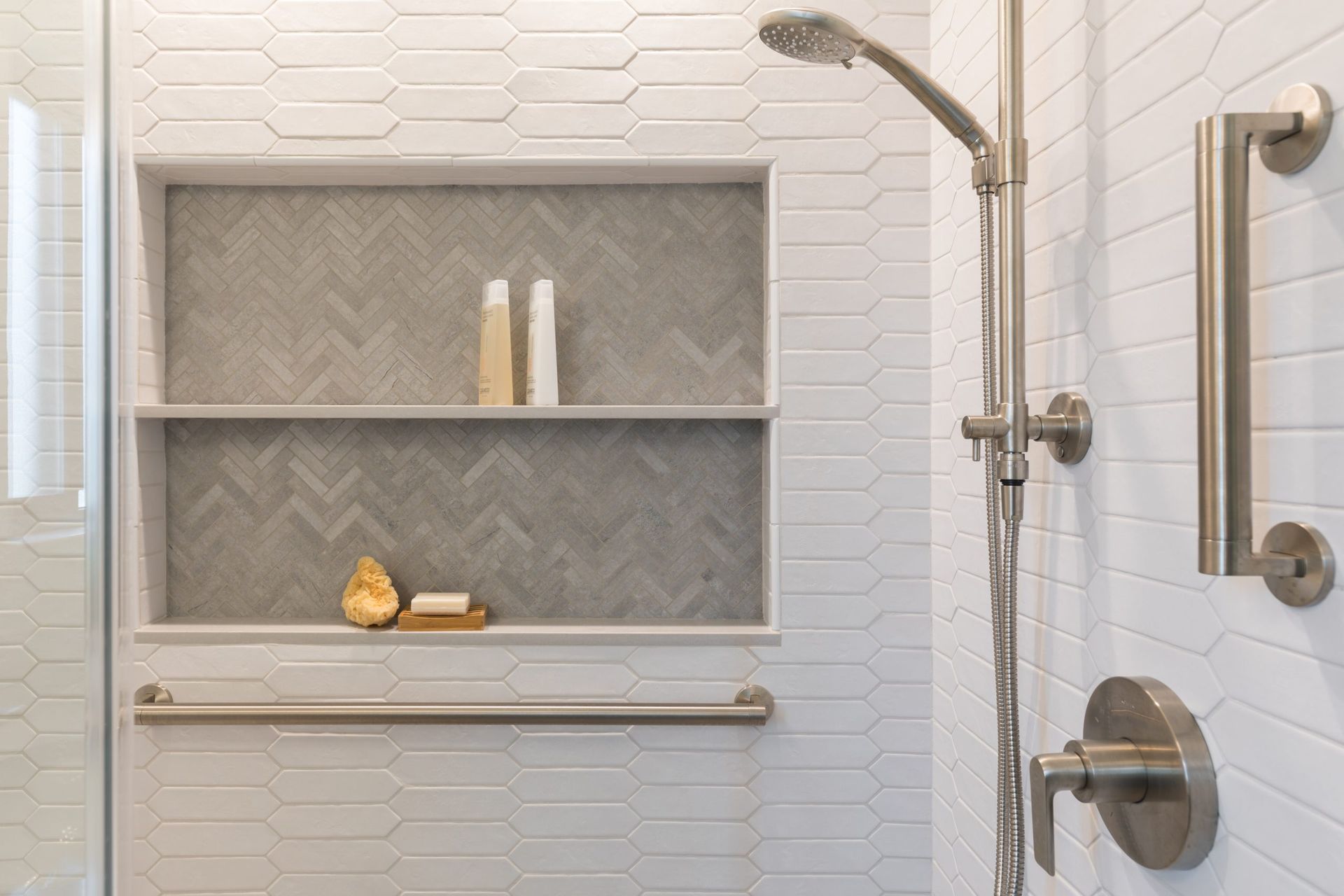 A shower with a shelf and a shower head.