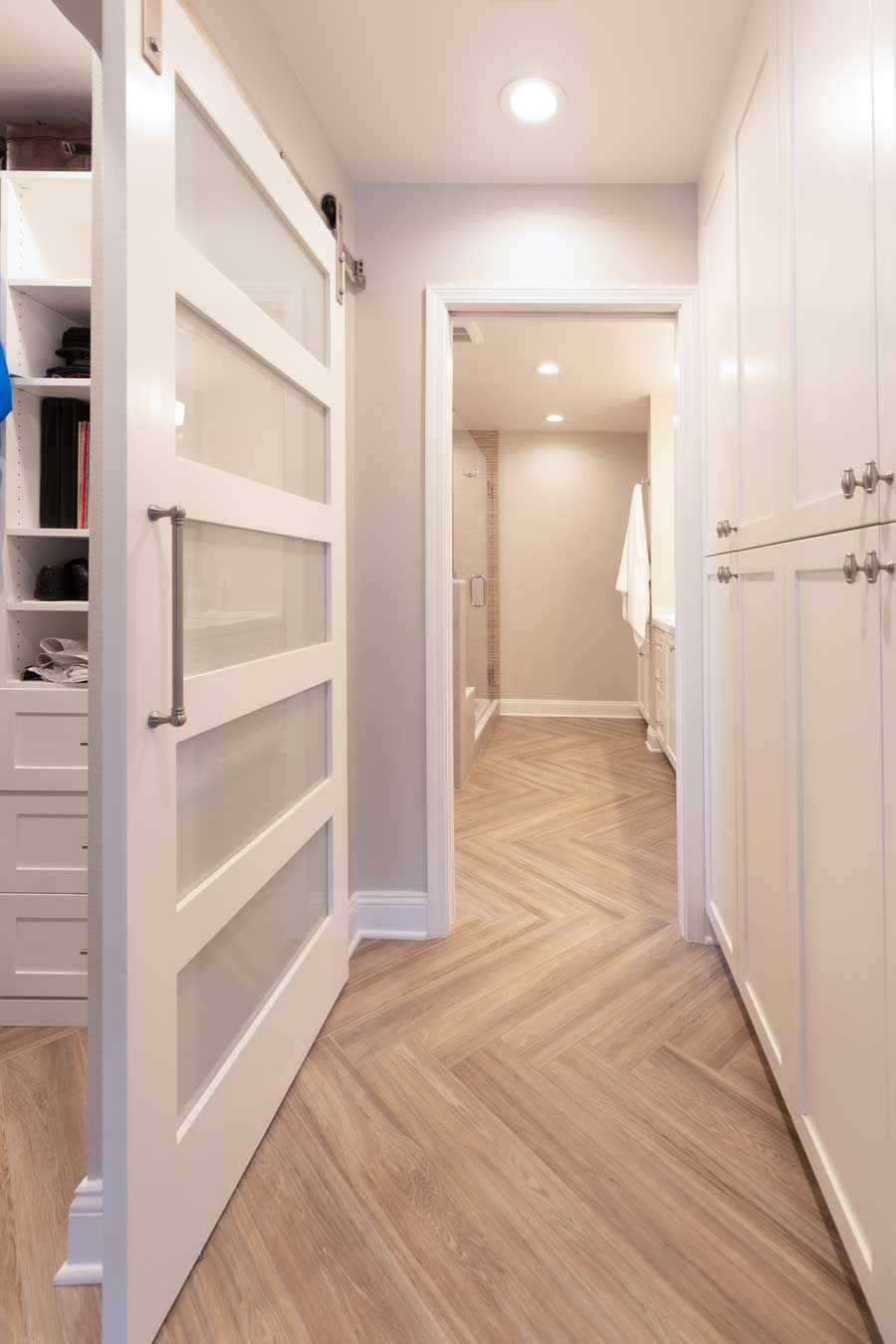 A hallway with a sliding glass door leading to a bathroom.