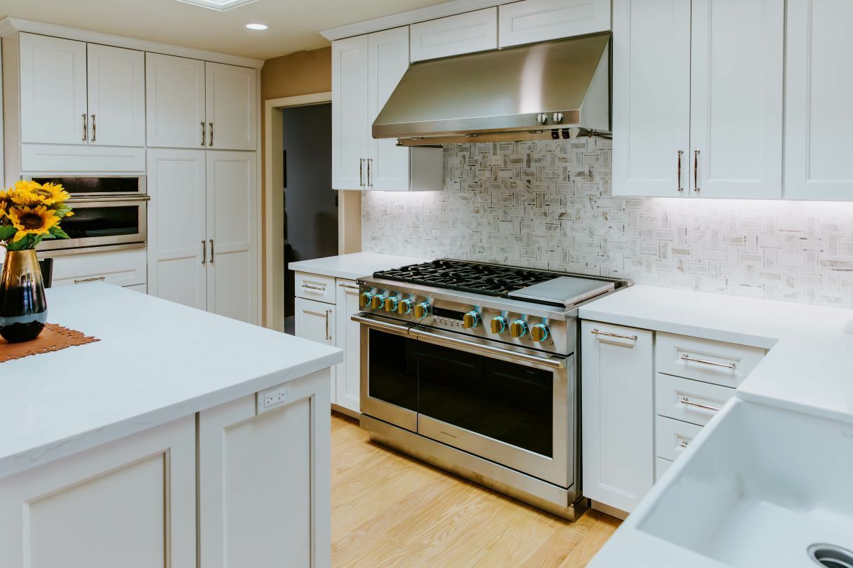 A kitchen with white cabinets and stainless steel appliances.