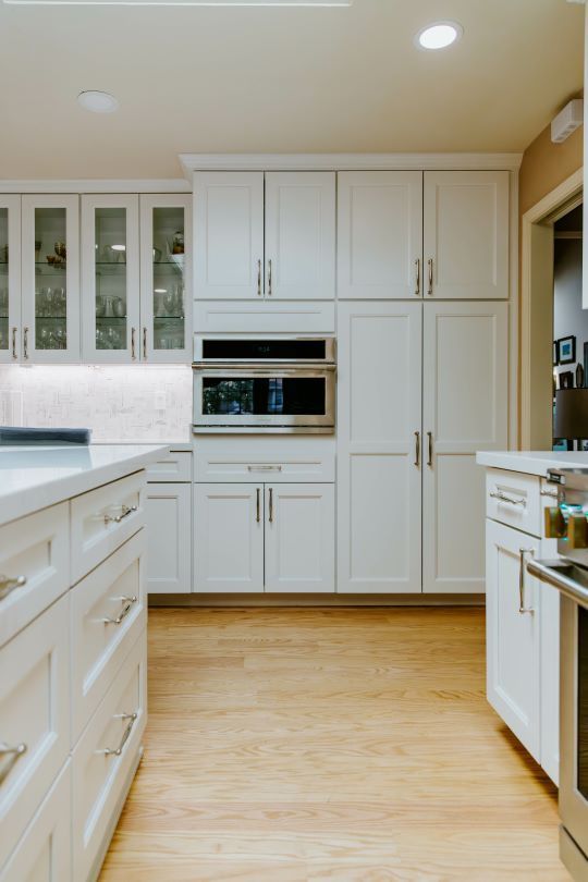 A kitchen with white cabinets and stainless steel appliances