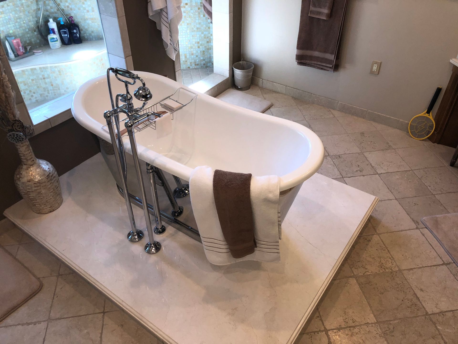 A bathtub is sitting on a tiled floor in a bathroom.