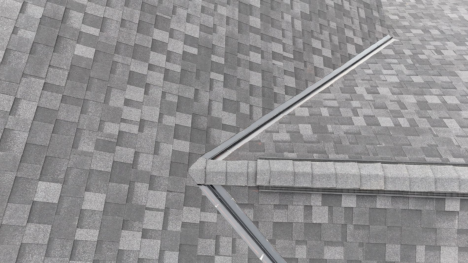 Gray asphalt shingle roof with a metal flashing.