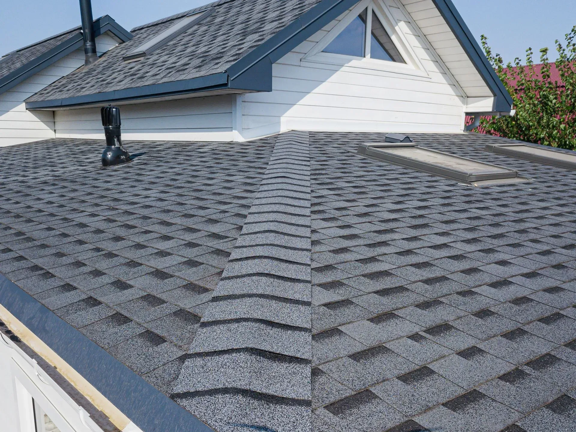 Close-up of a house roof with gray asphalt shingles.