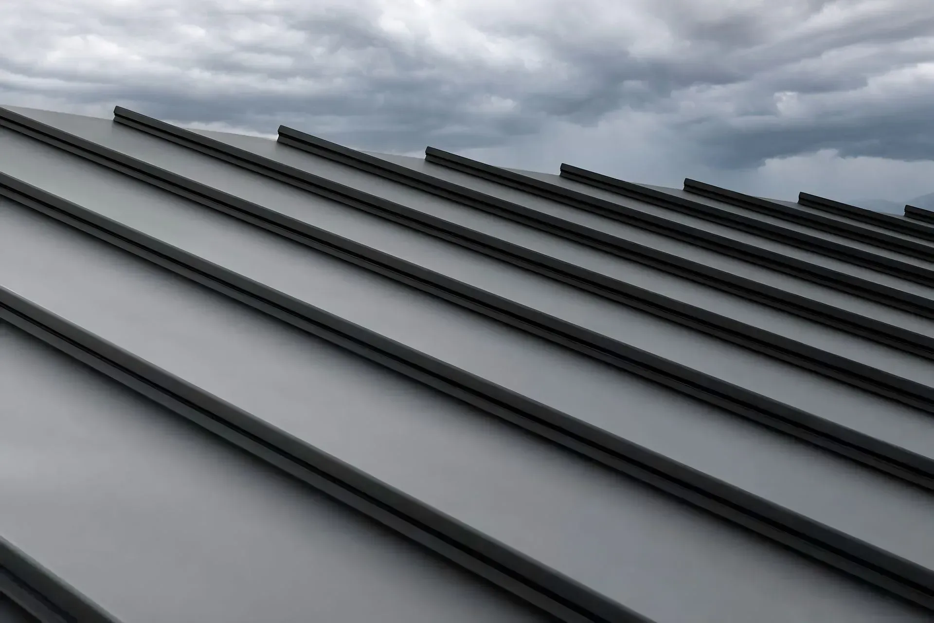Gray metal roof panels against a cloudy sky.