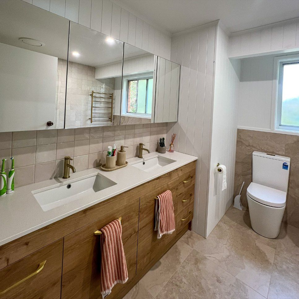 A Bathroom with Two Sinks, a Toilet and A Window — Coastal Homes & Renovations in Dondingalong, NSW