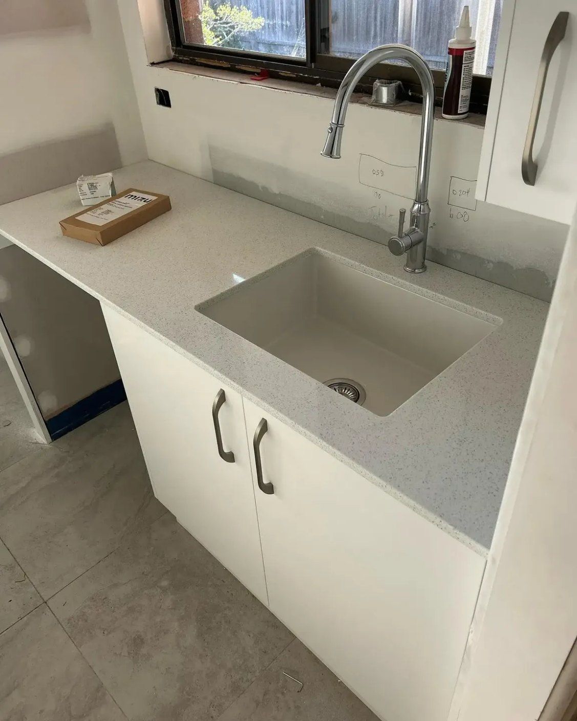 A Kitchen Sink with White Cabinets and A Faucet — Coastal Homes & Renovations in Laurieton, NSW