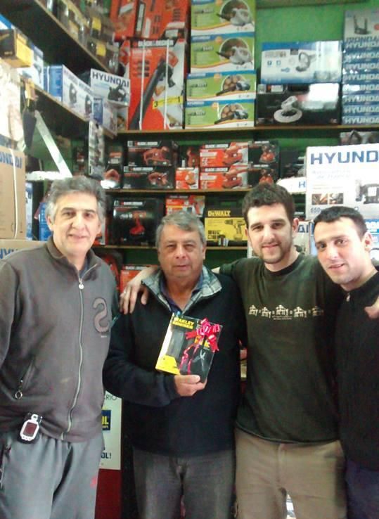 Caja de herramientas Stanley negra con herramientas amarillas y negras, abierta, con herramientas adicionales y guantes.