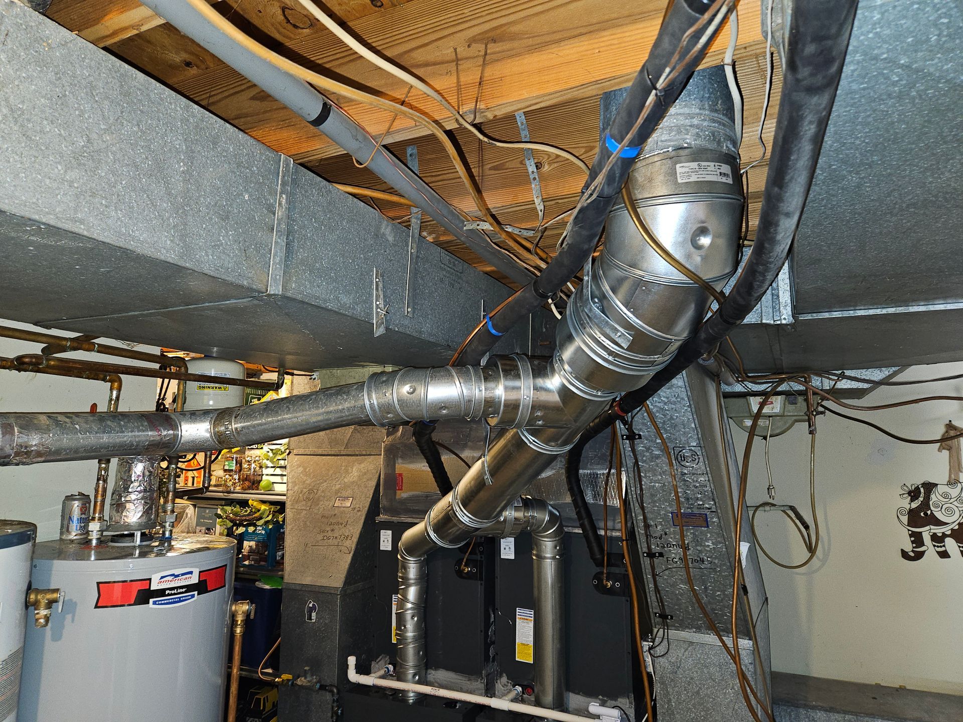HVAC ductwork and pipes in a basement setting. Includes a water heater, furnace, and various ducting components.