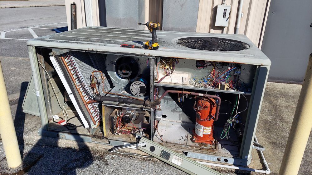 An open air conditioning unit with components exposed for repair. 