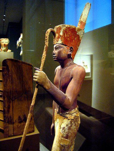 A statue of a man holding a cane in a museum