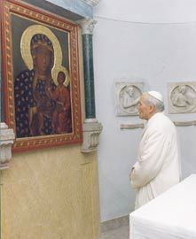 A man is looking at a painting of a woman and child on a wall.
