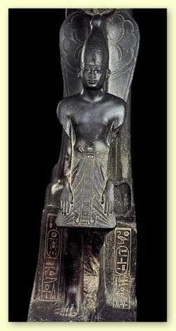 A close up of a statue of a man sitting on a rock.