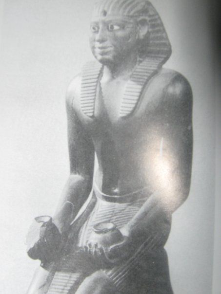 A black and white photo of a statue of a man holding two vases.