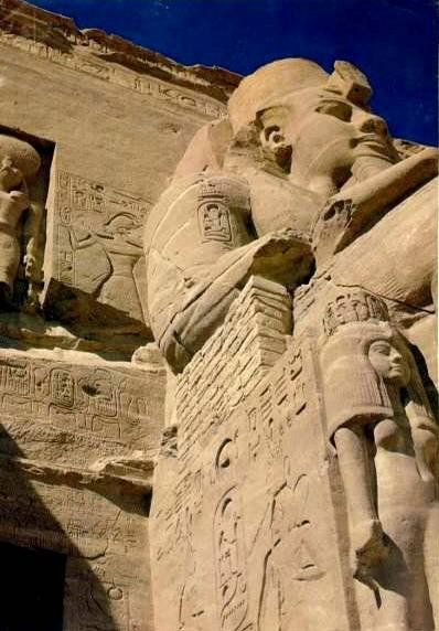 A statue of a man standing on a pillar with a blue sky in the background