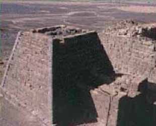 An aerial view of a pyramid in the desert.