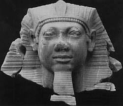 A black and white photo of a statue of a pharaoh 's head.