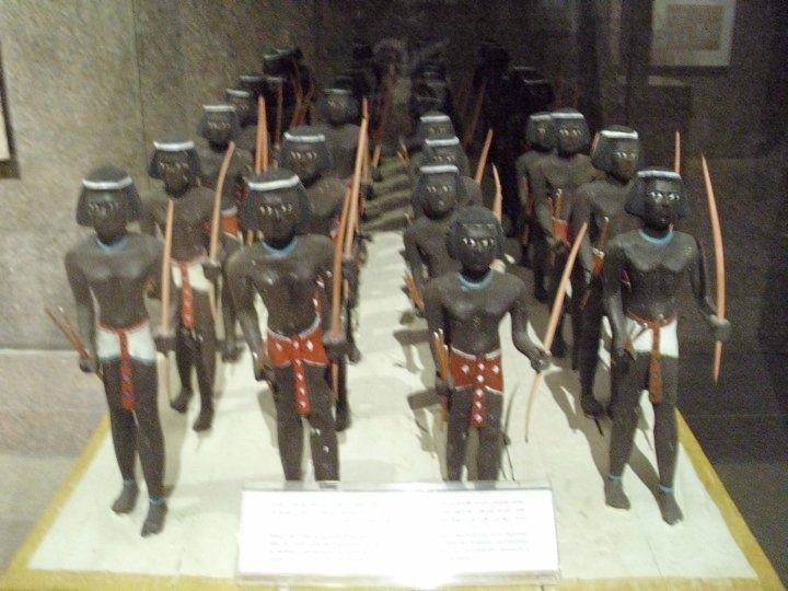 A group of statues of men holding bows and arrows