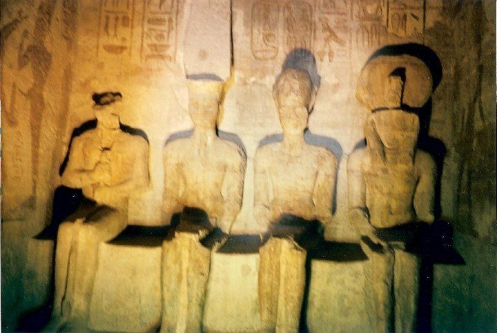 A group of statues are sitting next to each other in a dark room.